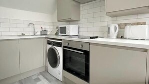 Una cucina moderna dotata di lavatrice, microonde e forno.