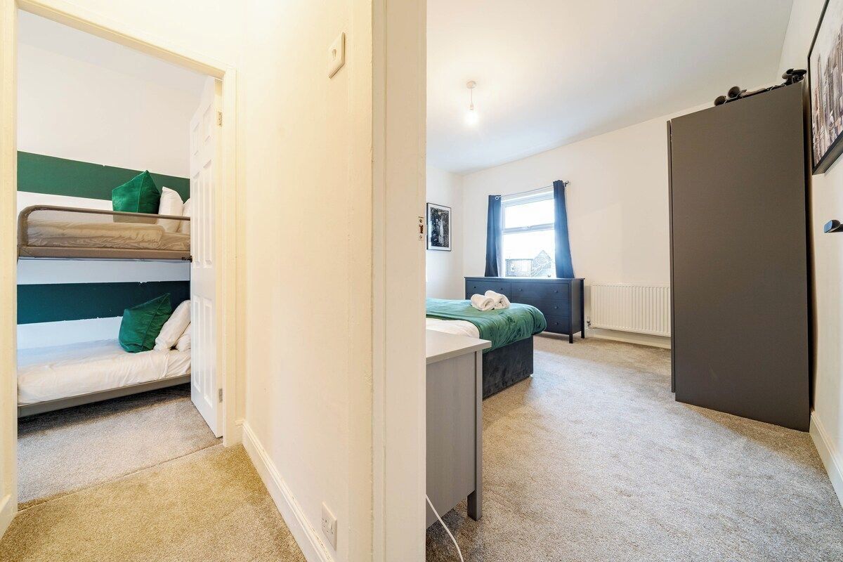 A room with bunk beds, a desk, a radiator, and a wardrobe.