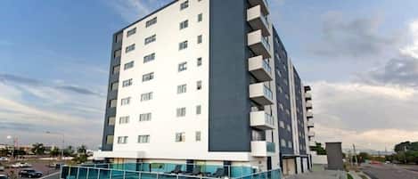 A modern multi-story hotel with a rooftop pool area.