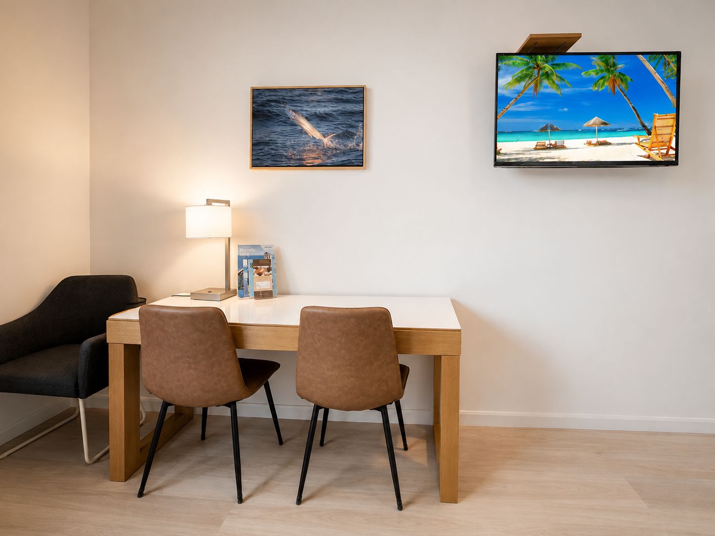 Un comedor con una mesa, sillas, una lámpara y dos cuadros en la pared.