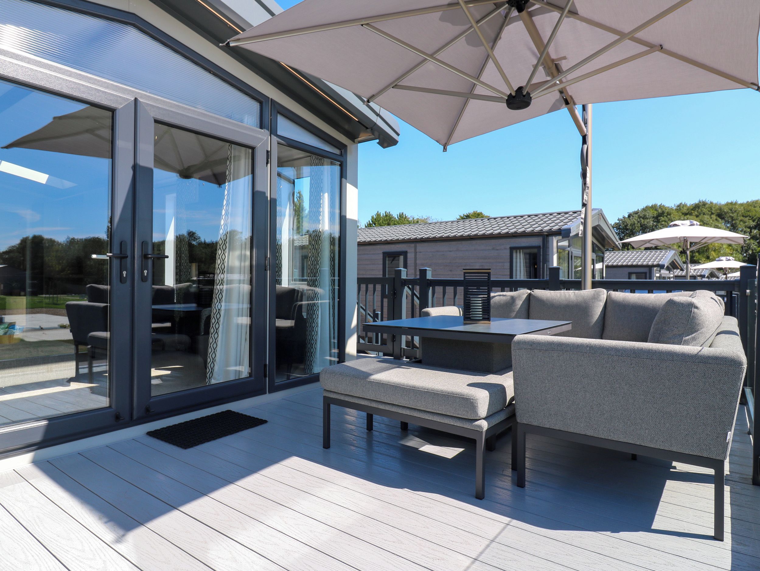 An outdoor patio with a glass door entrance, a table, and a sofa.