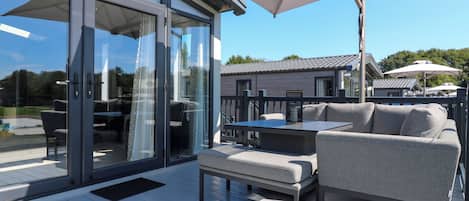 An outdoor patio with a glass door entrance, a table, and a sofa.