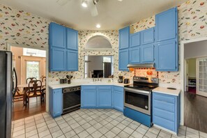 A kitchen with blue cabinets, a stove, and a dishwasher. - Matthews Family Home w/ Fenced Yard! (Matthews)