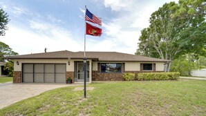 En boligbygning med garage, flagstang med amerikansk flag og en velholdt græsplæne.