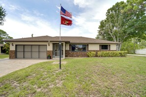 Ein Wohngebäude mit Garage, einer Fahnenstange mit amerikanischer Flagge und einem gepflegten Rasen.