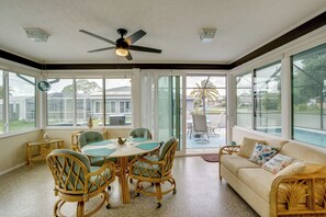 A sunroom with a ceiling fan, a dining table with chairs, and a sofa. - 4 Mi to Beaches! Family Getaway w/ Pool in Venice (Venice)