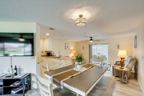 A modern living room with a dining area, a kitchen in the background, and a view through a glass door. - 4 Mi to Beaches! Family Getaway w/ Pool in Venice (Venice)
