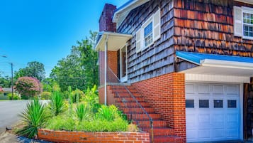 A two-story house with a brick foundation and a shingled exterior.
