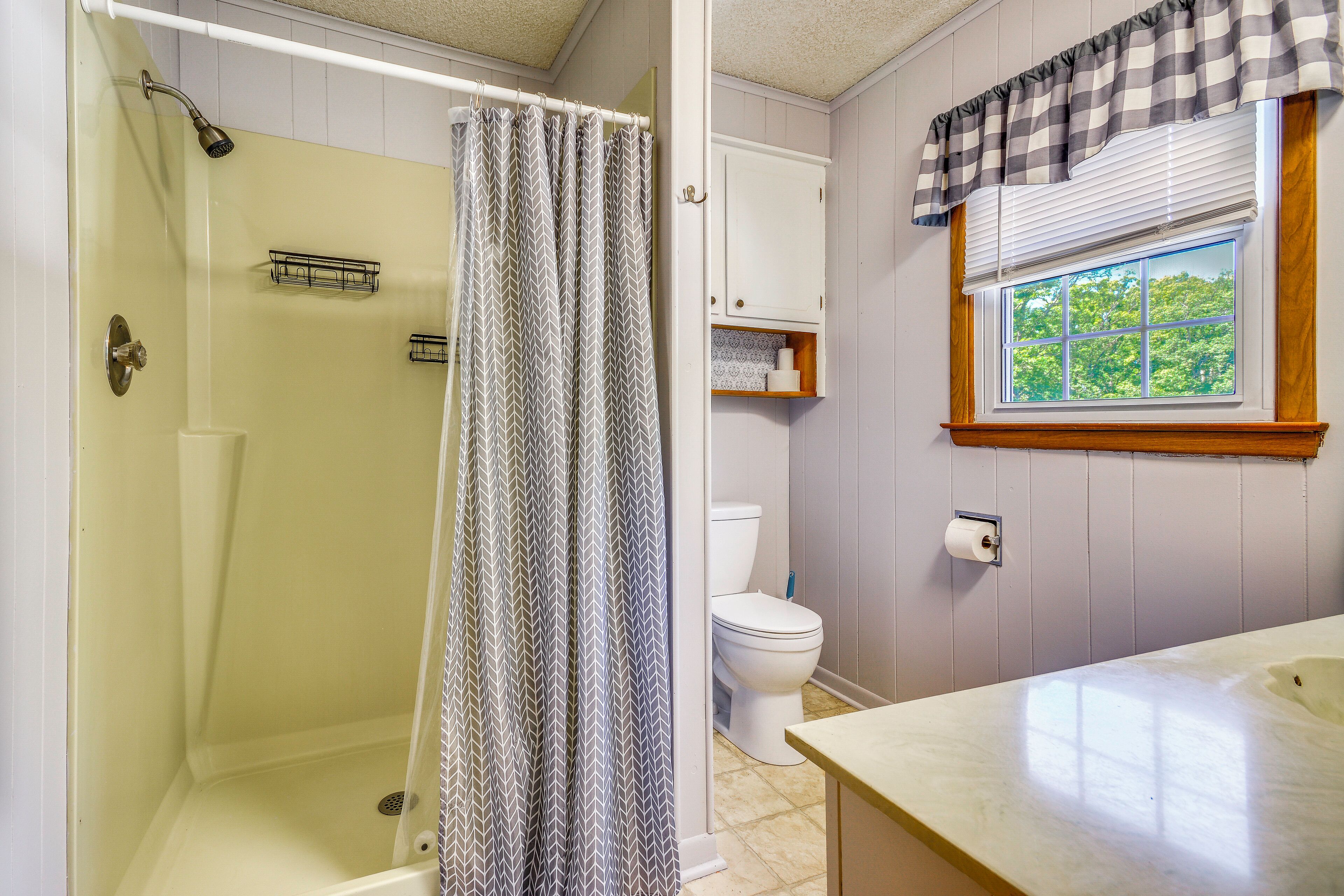 A bathroom with a shower, toilet, and sink.