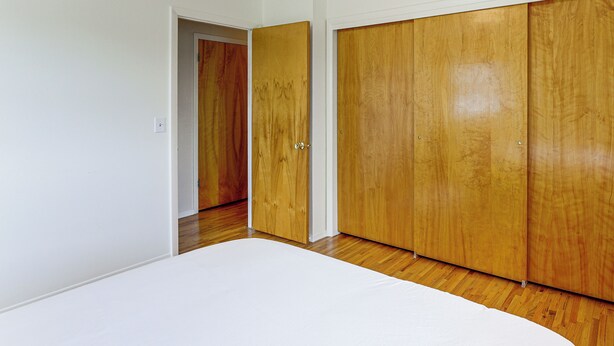 A room with a wooden wardrobe, a white door, and a wooden floor. - City Limits in Historic Spearfish, South Dakota (Spearfish)
