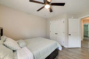 A bedroom with a bed, a ceiling fan, and a door leading to another room. - 8 Mi to Fort Campbell! Family Home w/ Patio & Yard (Clarksville)