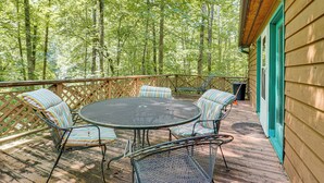A wooden deck with a round metal table and chairs, surrounded by a wooden fence. - 9 Mi to Lake Keowee! Secluded Creekfront Getaway (Sunset)