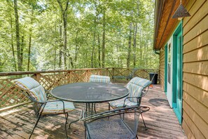 A wooden deck with a round metal table and chairs, surrounded by a wooden fence. - 9 Mi to Lake Keowee! Secluded Creekfront Getaway (Sunset)