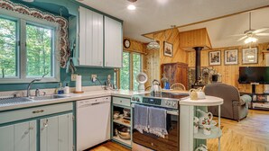 A kitchen with wooden cabinets, a stove, and a dining area with a television.