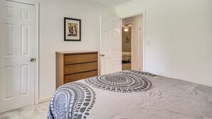 A bedroom with a bed, a dresser, and two doors. - Family Getaway w/ Pool on 8 Acres in Carriere! (Carriere)