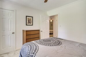 A bedroom with a bed, a dresser, and two doors. - Family Getaway w/ Pool on 8 Acres in Carriere! (Carriere)