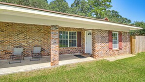 A single-story brick house with a covered porch, a front door, and a window. - Family Getaway w/ Pool on 8 Acres in Carriere! (Carriere)