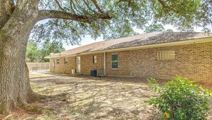 A brick building with a large tree in the foreground. - Family Getaway w/ Pool on 8 Acres in Carriere! (Carriere)