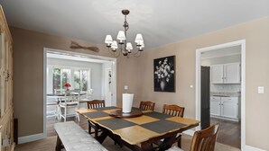 A dining room with a wooden table, chairs, a bench, a chandelier, and a painting on the wall. - Private Pool & Basketball Spacious 3BR Sleeps 9 (Wenatchee)