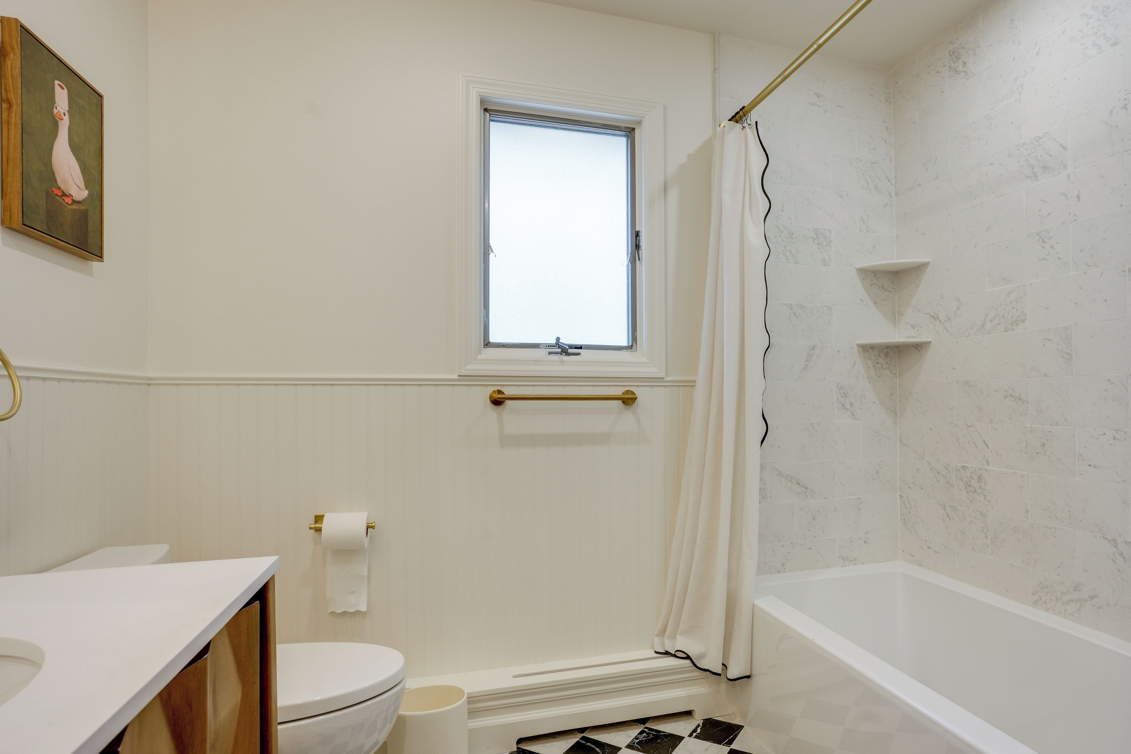 A bathroom with a toilet, sink, and bathtub.