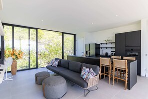 Ein stilvolles Wohnzimmer mit Sofa, Hocker und Barhocker.