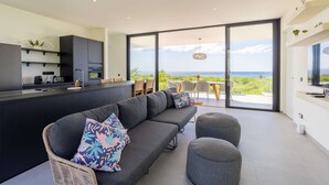 Une cuisine moderne dotée d’un four encastré et d’un coin repas offrant une vue sur la mer.