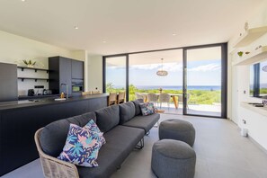 Eine moderne Küche mit Einbauofen und Essbereich mit Meerblick.