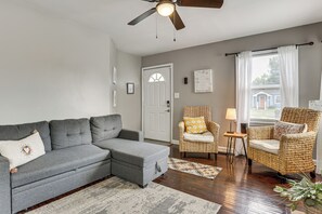 A living room with a grey sectional sofa, a wicker chair, and a small side table. - 4 Mi to Downtown Columbus! Updated Home w/ Yard (Columbus)