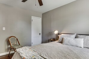 A bedroom with a bed, a chair, a bedside table with a lamp, and a door. - 4 Mi to Downtown Columbus! Updated Home w/ Yard (Columbus)