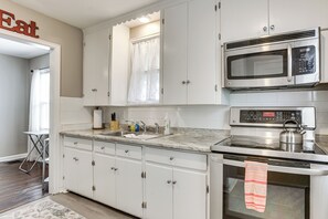 A kitchen with white cabinets, a microwave, an oven, and a sink. - 4 Mi to Downtown Columbus! Updated Home w/ Yard (Columbus)