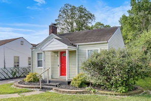 A single-story house with a red door, a small porch, and a brick chimney. - 4 Mi to Downtown Columbus! Updated Home w/ Yard (Columbus)