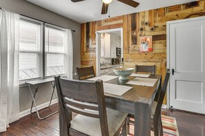 A dining area with a wooden table, chairs, and a view of the kitchen through an open doorway. - 4 Mi to Downtown Columbus! Updated Home w/ Yard (Columbus)