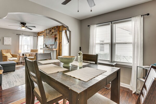 A dining area with a wooden table, chairs, and a decorative bowl. - 4 Mi to Downtown Columbus! Updated Home w/ Yard (Columbus)