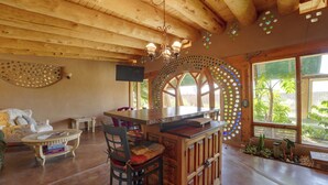 Ein Holzinterieur mit Bar, Sitzgelegenheiten und großen Fenstern.