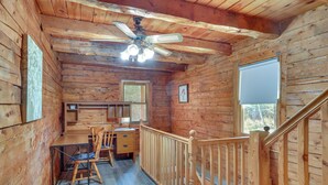 A wooden cabin interior with a dining area, a ceiling fan, and a staircase. - Classic New England Cabin on Belleau Lake (Wakefield)