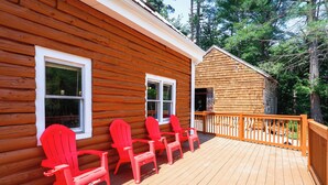 A wooden cabin with a deck, two windows, and a small shed. - Classic New England Cabin on Belleau Lake (Wakefield)