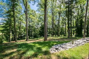 A forested area with a stone wall and a sign indicating a protected area. - Druid Hills Retreat II Sleeps 8 Free Tix (Hendersonville)