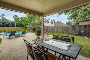 An outdoor patio area with a pool, seating, and a view of the backyard. - Near Splashtown & The Woodlands! Poolside Retreat (Tomball)