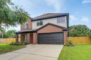 A two-story house with a garage, a front porch, and a well-maintained lawn. - Near Splashtown & The Woodlands! Poolside Retreat (Tomball)