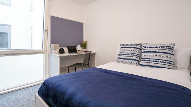 Ein Schlafzimmer mit einem Bett, einem Schreibtisch und einem Stuhl.