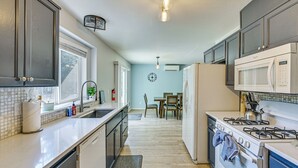 A kitchen with a stove, microwave, and sink.
