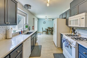 A kitchen with a stove, microwave, and sink.
