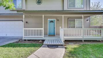 A two-story house with a front porch, a garage, and a blue door.