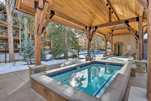 A covered outdoor pool area with a wooden deck and stone walls. - Steps to the Slopes! Breck Ski Condo w/ Fireplace (Breckenridge)