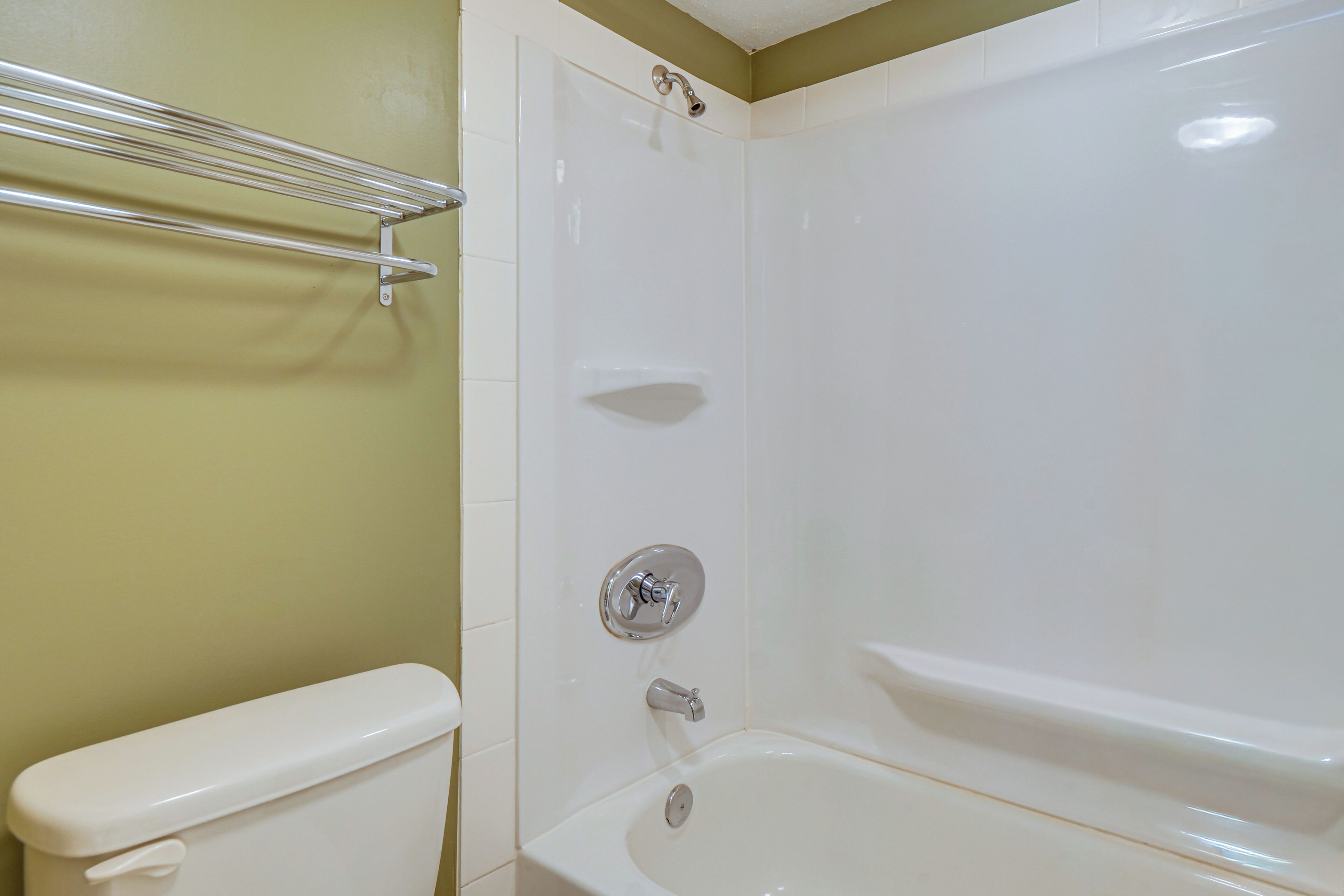A bathroom with a toilet, a bathtub, and a shower.