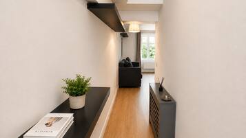 A modern hallway with a black countertop, a potted plant, and a book.