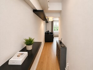A modern hallway with a black countertop, a potted plant, and a book. - Spacious studio flat in Notthing Hill (London)