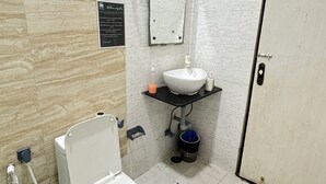 Un baño con inodoro, lavamanos y espejo.