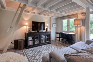 A bedroom with a bed, a desk, a television, and a window with curtains. - The Cabin – A Boutique Retreat in the New Forest (Brockenhurst)