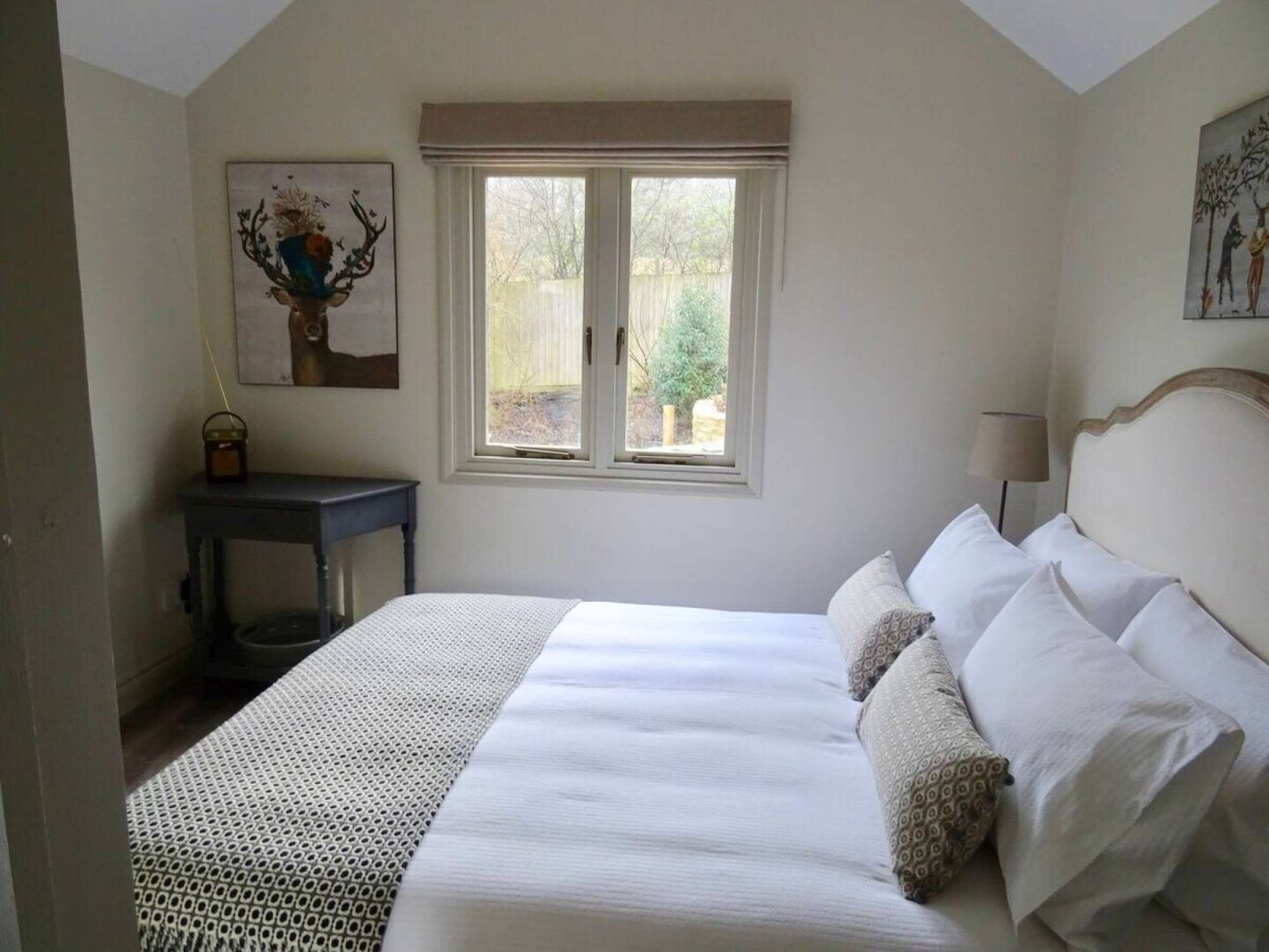 A bedroom with a bed, a window, a desk, and a chair.
